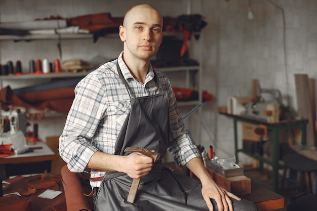 Man in een studio maakt lederwaren