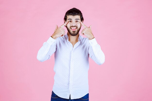 Man in een wit overhemd denken of ziet er attent uit.