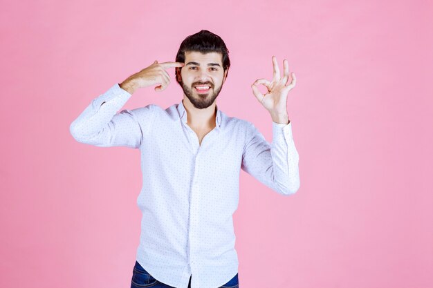 Man in een wit overhemd denken of ziet er attent uit.