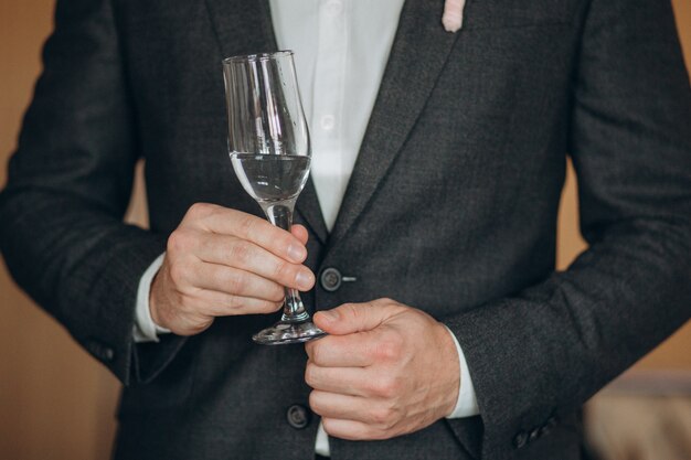 man in een wit shirt met een glas champagne shows