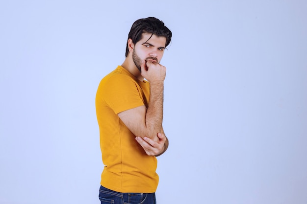 Man in geel overhemd verleidelijke en aantrekkelijke poses geven.