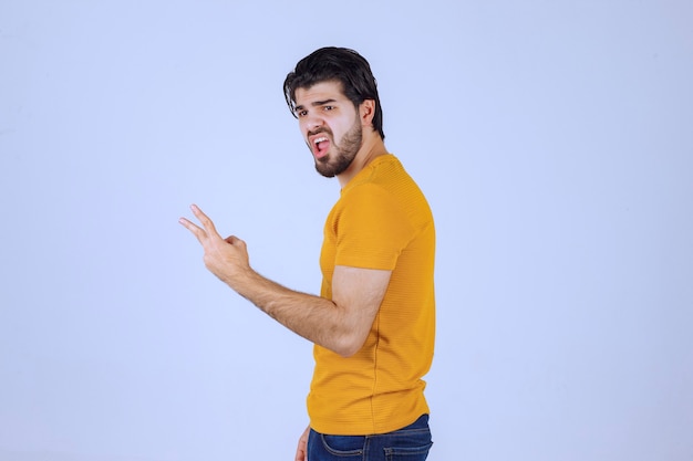 Man in geel shirt met teken van vrede en vriendschap