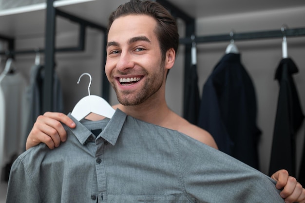 Man in geruite thuisbroek die een shirt kiest om te dragen