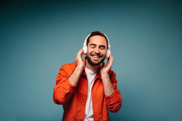 Man in lichte outfit geniet van muziek in koptelefoon