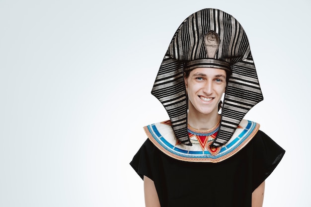Man in oud Egyptisch kostuum gelukkig en positief op wit