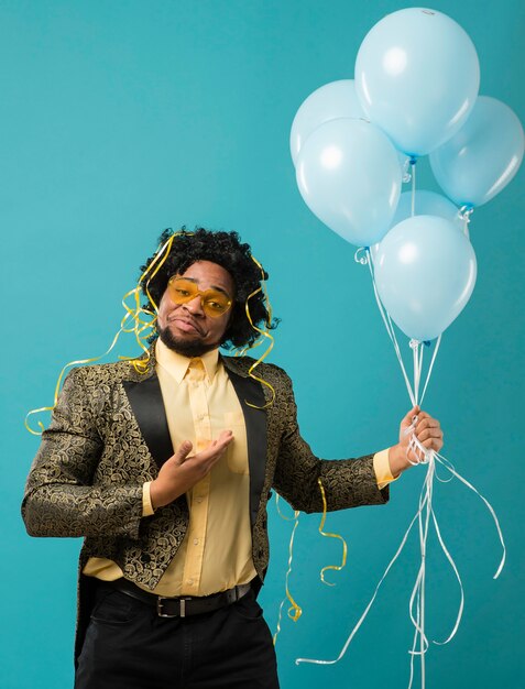 Man in pak en zonnebril op feestje met ballonnen portret