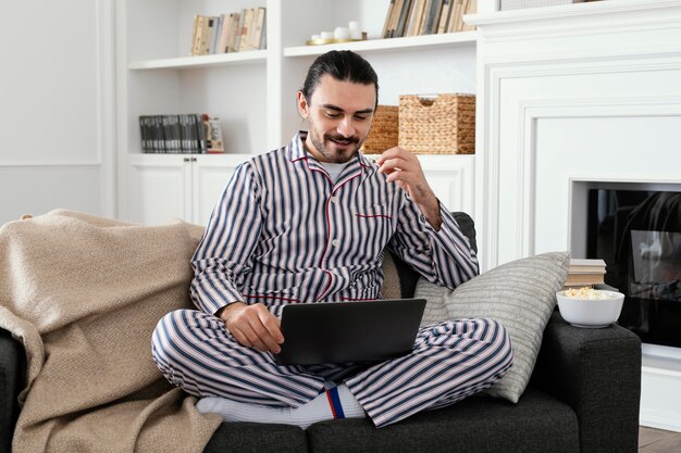 Man in pyjama's leuke tijd doorbrengen op laptop
