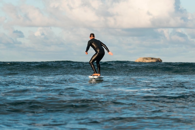 Gratis foto man in speciale uitrusting surfen in hawaï