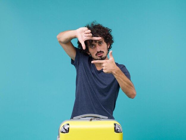 man in vakantie in blauw t-shirt met fototeken op blauw