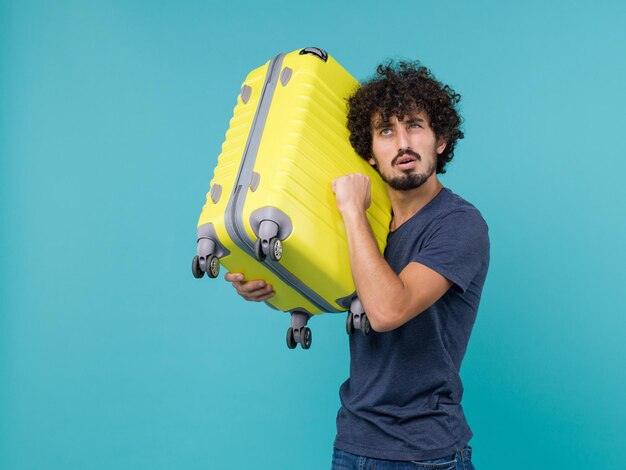 man in vakantie met gele tas op het lichtblauw