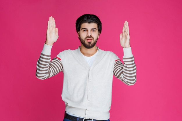 Gratis foto man in wit overhemd die ergens naar wijst en iemand introduceert of gewoon de richting aangeeft.