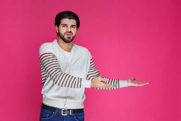 Man in wit overhemd wijst naar iets met zijn wijzende vinger.