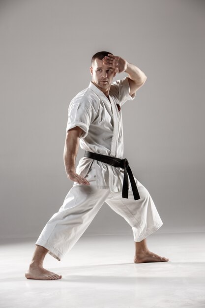 Man in witte kimono training karate