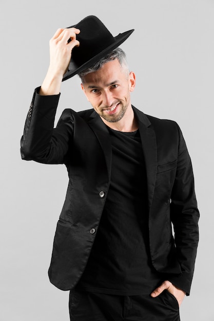 Man in zwart pak begroet met zijn hoed