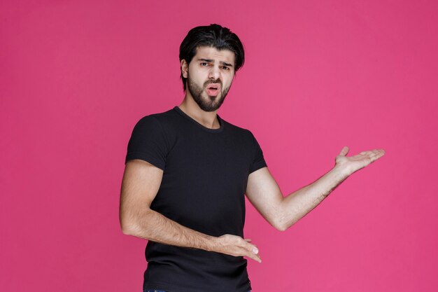 Man in zwart shirt die zich negatief en teleurgesteld voelt over iets