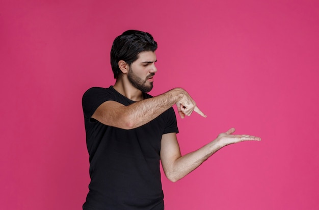 Man in zwart shirt met iets in zijn hand