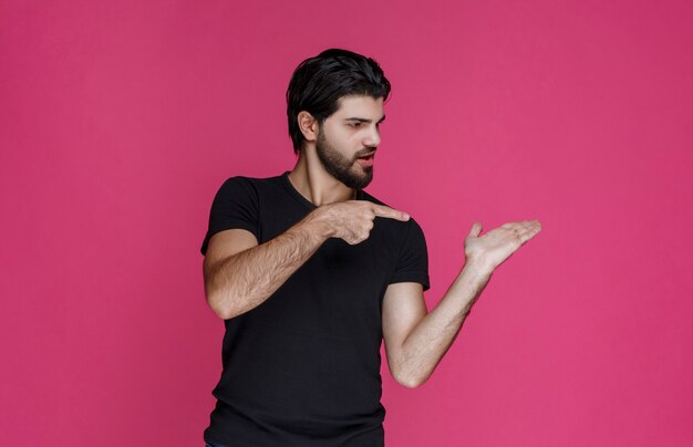 Man in zwart shirt met iets in zijn hand