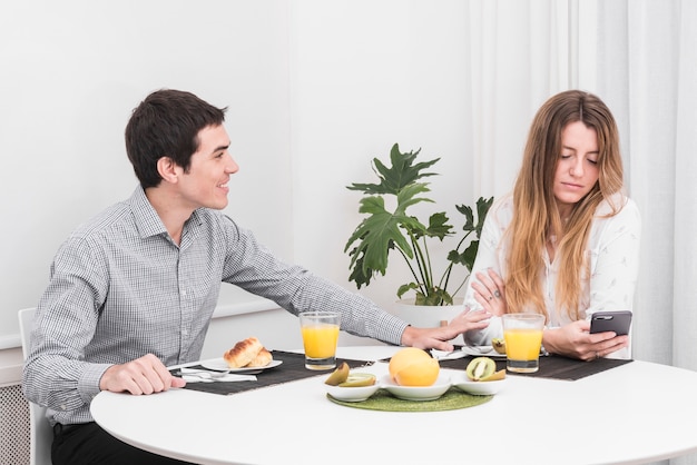 Man kalmerende vrouw aan tafel