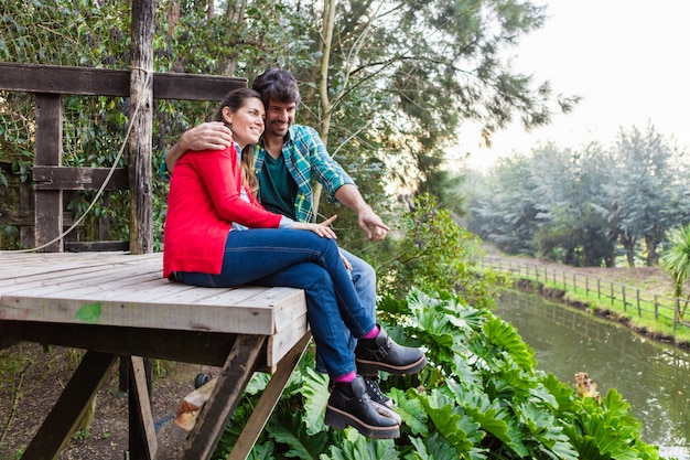 Gratis foto man knuffelen zijn vrouw en het tonen van iets