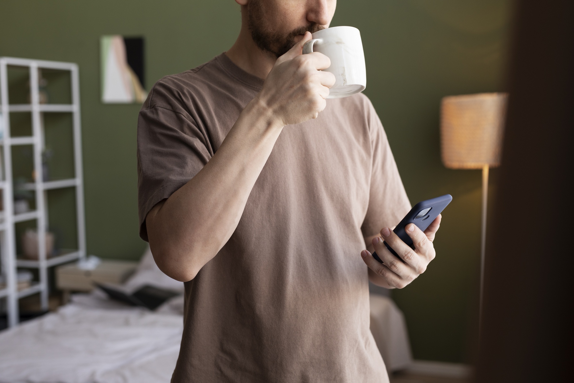 Man koffie drinken en het controleren van e-mails op smartphone
