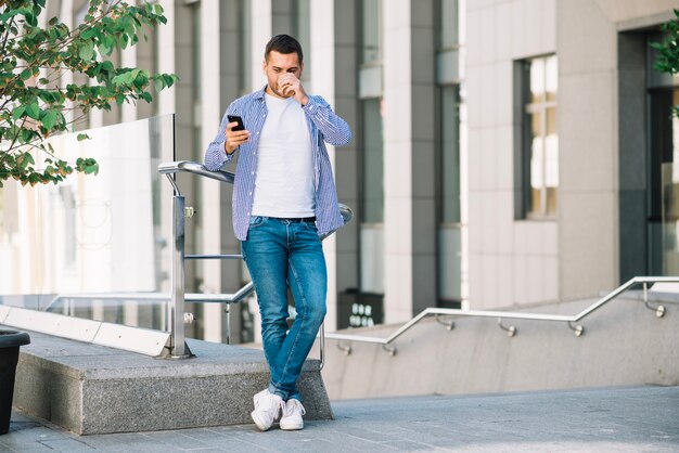 Man koffie drinken in de buurt van de leuning