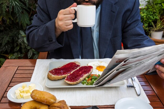 Man krant lezen en koffie drinken in restaurant
