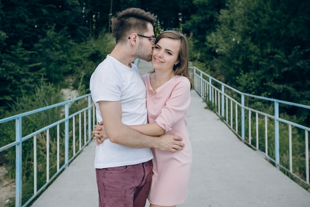 Gratis foto man kussen in het gezicht zijn meisje op een brug