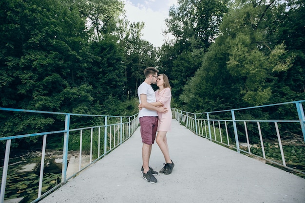 Man kussen in het gezicht zijn meisje op een brug