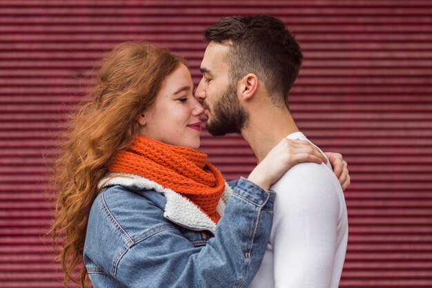 Man kussen vriendinnen neus vooraanzicht