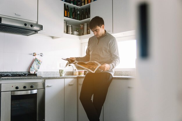 Man leest de krant in de keuken