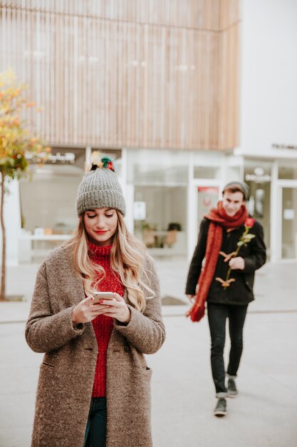 Man lopen naar vriendin met roos geschenk