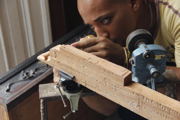 Man maakt houten planken binnenshuis op een tafel