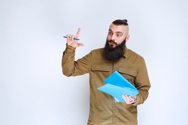 Man met baard die een quizpapier vasthoudt en er verward en attent uitziet.