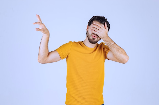 Man met baard die geschatte afmetingen van een object toont.