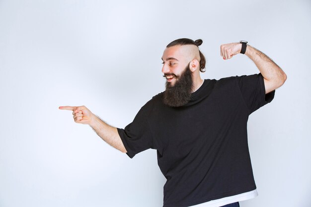 Man met baard die zijn armspieren en vuisten demonstreert.