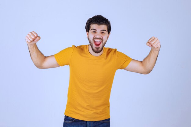 Man met baard die zijn vuist- en armspieren demonstreert en zich krachtig voelt