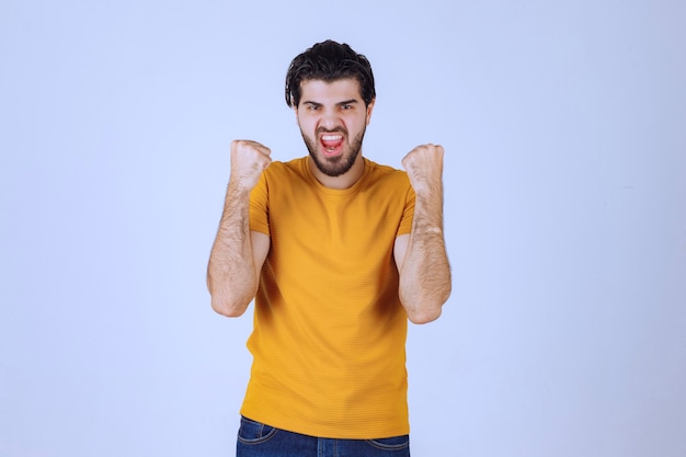 Man met baard die zijn vuist- en armspieren demonstreert en zich krachtig voelt