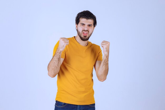 Man met baard die zijn vuist- en armspieren demonstreert en zich krachtig voelt