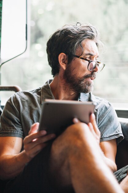 Man met baard kijken uit het raam