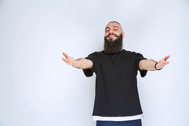 Man met baard wijzend naar iemand in de buurt.