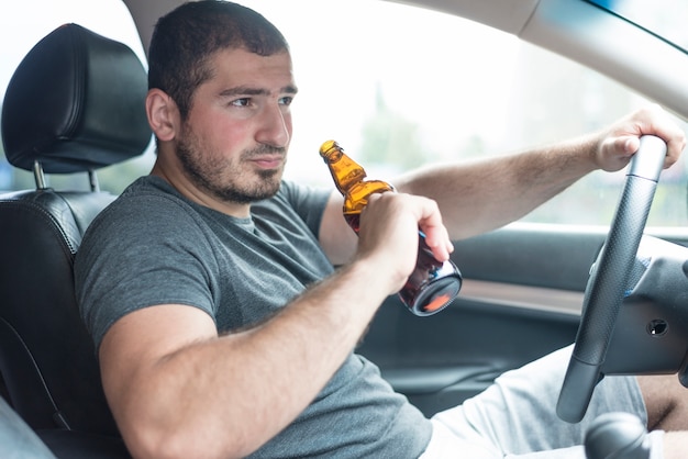 Man met bier rijdende auto