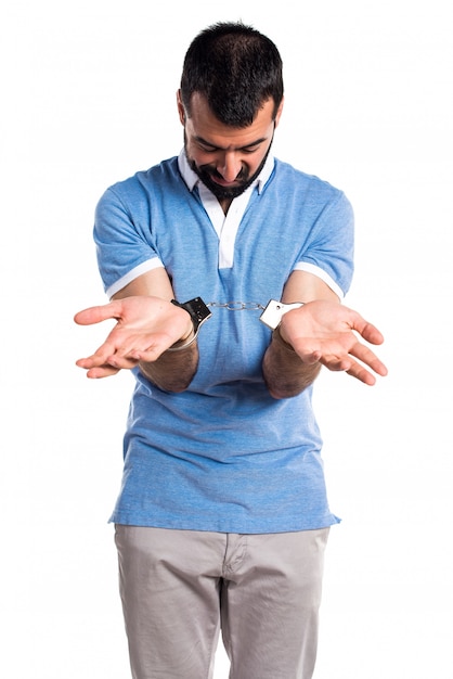 Man met blauw shirt met handboeien