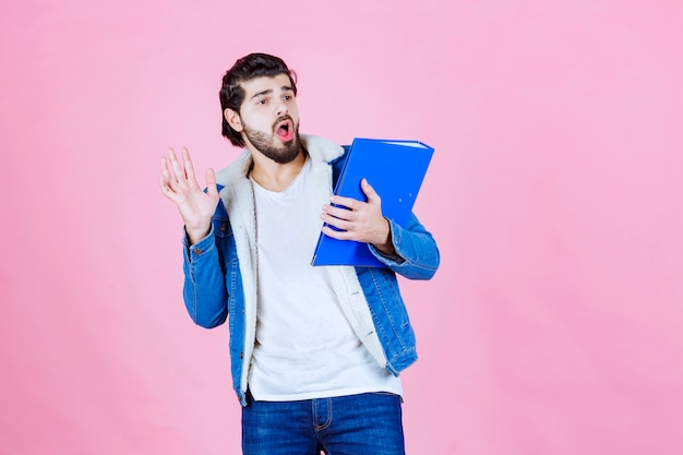 Man met blauwe map ziet er doodsbang en moe uit