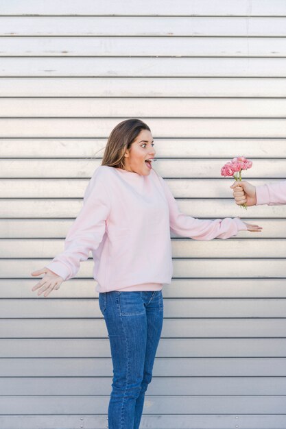 Man met bloemen in de buurt van verraste vrouw