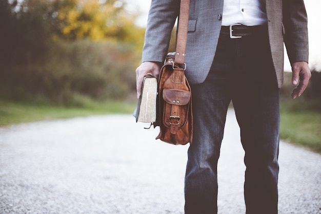 Man met boek op weg overdag