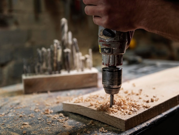 Man met boor die met hout werkt