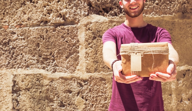 Man met cadeau voor muur