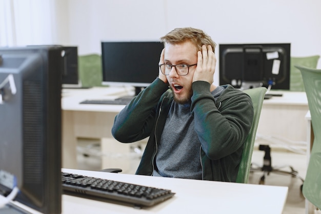 Man met de bril. Student in informatica klas. Persoon gebruikt een computer.