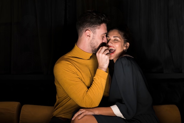 Man met de hand in de buurt van de monding van vrolijke vrouw