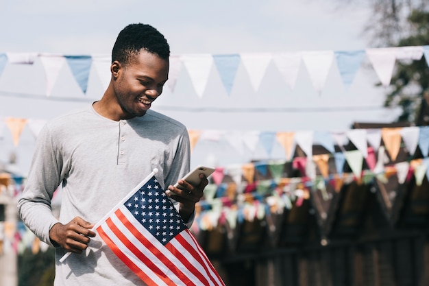 Gratis foto man met de vlag van de vs en smartphone